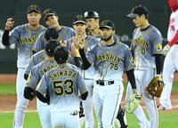９回、無失点に抑えた阪神　ロベルト・スアレスはナインとタッチを交わす＝マツダスタジアム（撮影・田中太一）