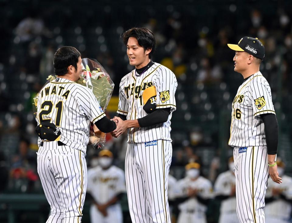 阪神・岩田稔（左）は阪神・藤浪晋太郎と阪神・秋山拓巳から花束を贈られる＝甲子園（撮影・山口登）