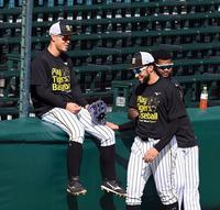 佐藤輝（左）は外野のラバーフェンスに座りスアレスと談笑する（撮影・山口登）