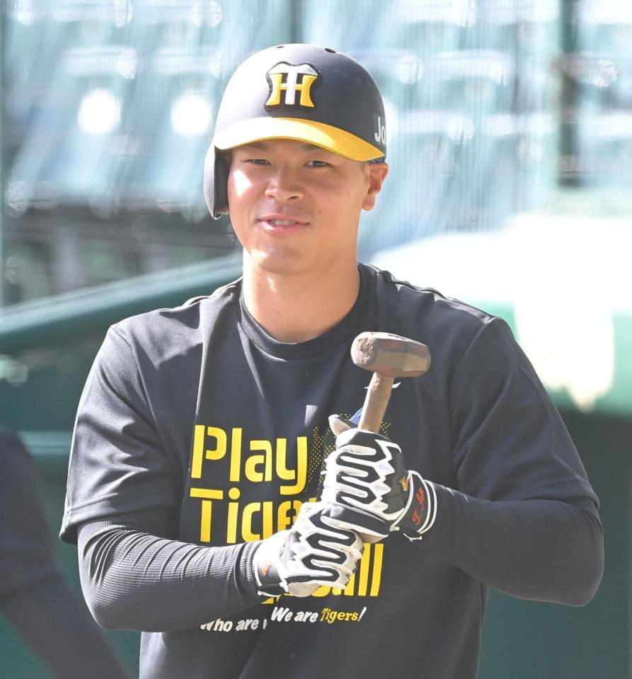 ハンマーを手に笑顔を見せる佐藤輝＝甲子園（撮影・高部洋祐）