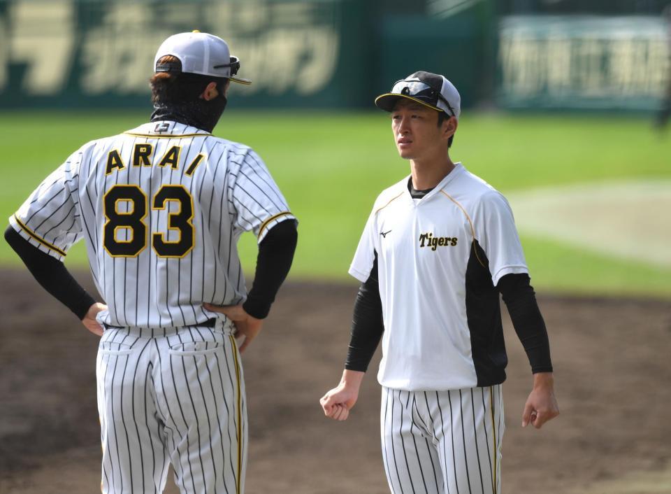 　新井良太コーチ（左）と談笑する近本（撮影・北村雅宏）