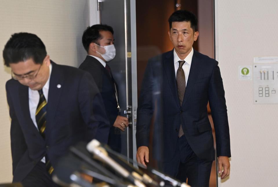 オーナー報告を終え、会見場に入る矢野監督（奥）