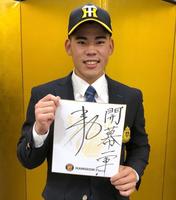 　仮契約を終え、「開幕１軍」と書いた色紙を手にする鈴木（阪神タイガース提供）