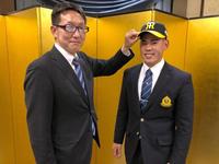 　仮契約を終え、吉野スカウト（左）から帽子をかぶせてもらう鈴木（阪神タイガース提供）