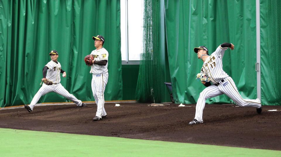 　春季キャンプのブルペンで投げ込む岩貞（右）、岩崎（左）ら＝２月