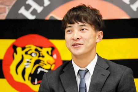 　アップ提示で契約を更改し会見場で笑顔を見せる熊谷（代表撮影）