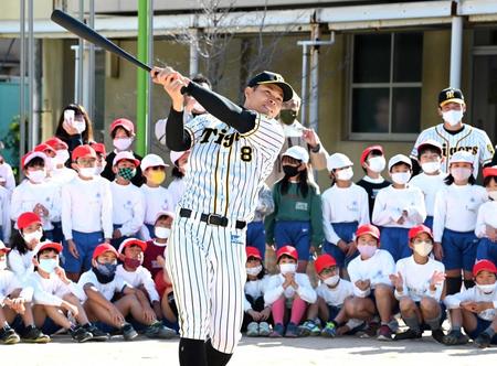 　生徒の前でフルスイングする佐藤輝（撮影・田中太一）