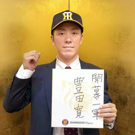 　色紙に目標を記しガッツポーズを決める豊田（球団提供）