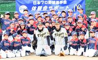 子どもたちと笑顔で記念写真におさまる阪神・小川一平（中央左）と阪神・小幡竜平＝吹田市・佐竹台小学校（撮影・飯室逸平）