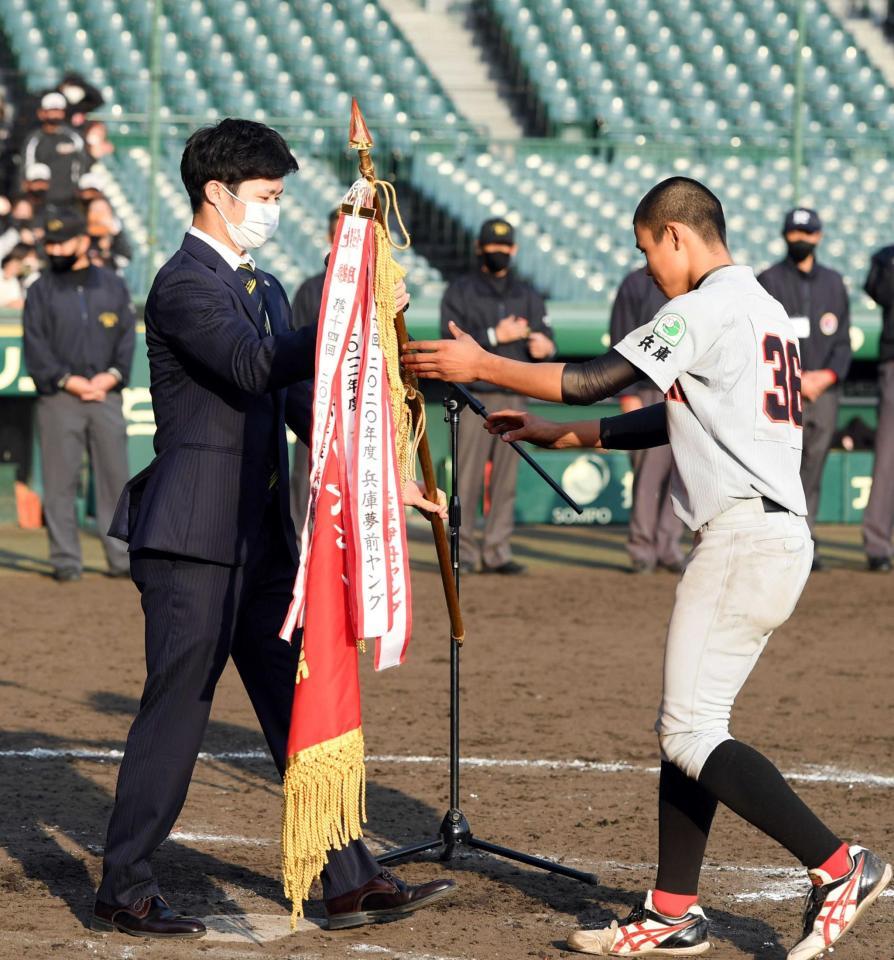 　中野（左）はタイガースカップを制した兵庫夢前ヤングに優勝旗を手渡す