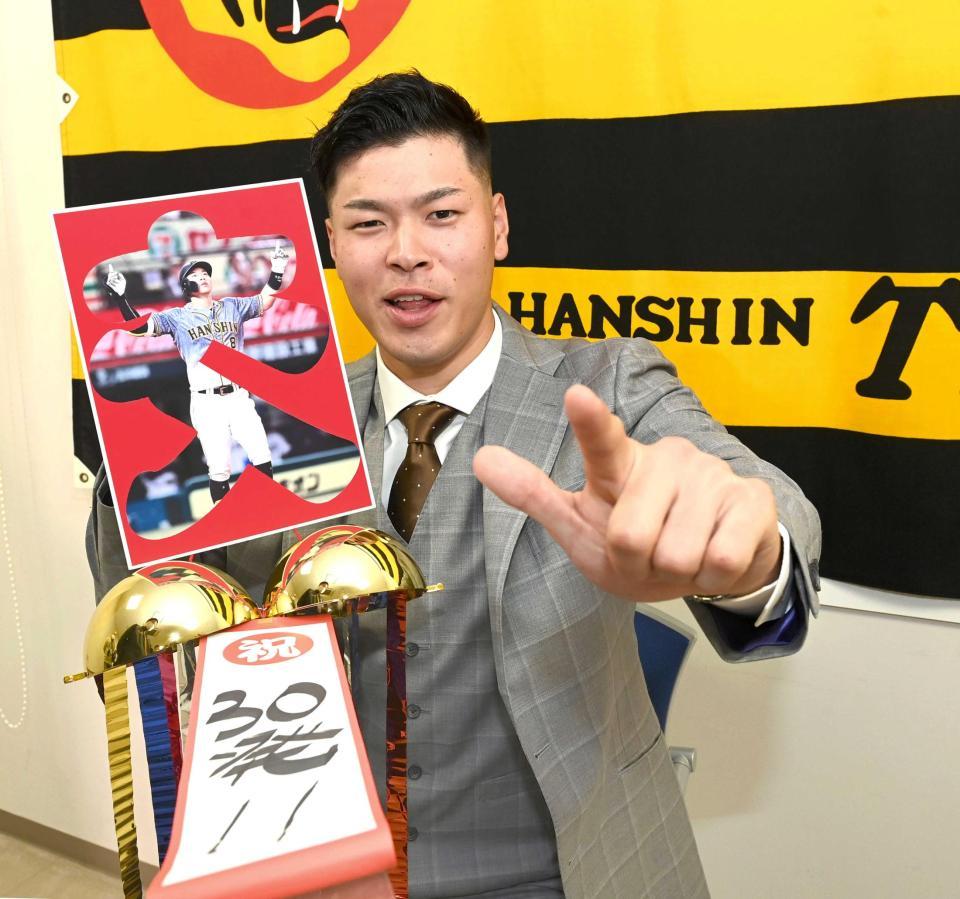 　来季の目標「３０発！！」としたため、ポーズを決める佐藤輝（撮影・飯室逸平）