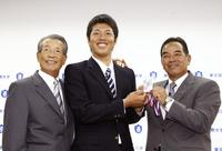 　ドラフト４位指名のあいさつを受け、笑顔の東京国際大・伊藤和。左は古葉監督＝１１年１１月４日