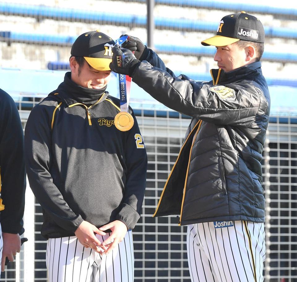 　岩崎（右）から東京五輪の金メダルを掛けられて照れ笑いする高橋（撮影・西岡正）