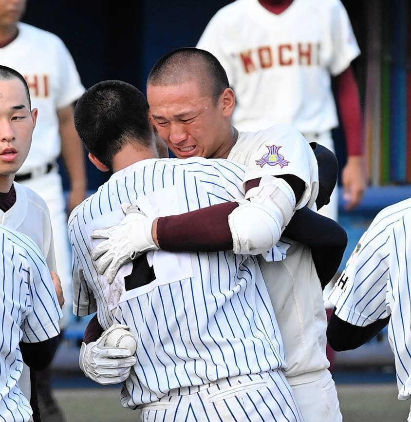 　明徳義塾・代木（左）と健闘をたたえ抱き合う森木。手にしているのが持参したボール＝２０２１年７月２８日