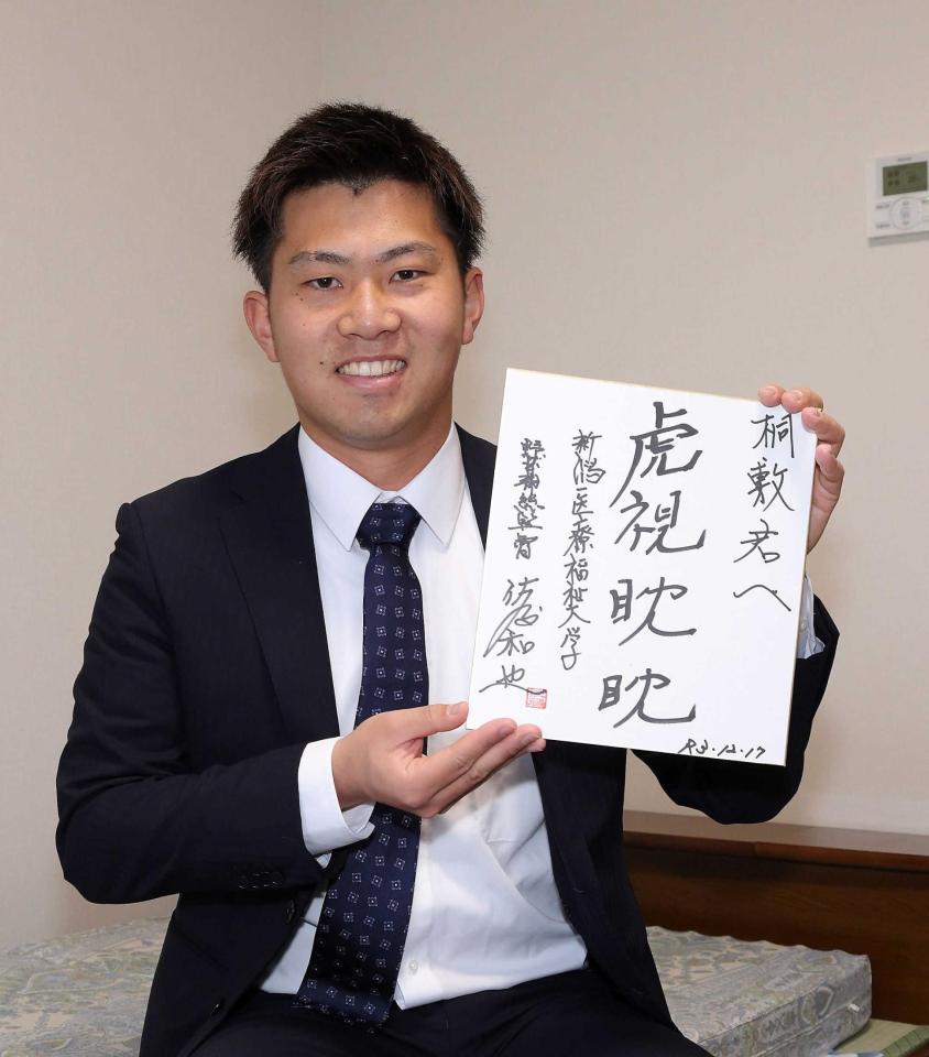 　恩師から贈られた色紙を手にする桐敷