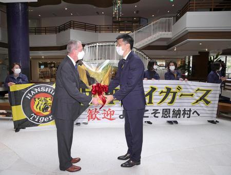 　キャンプ地の宿舎に到着し、花束を受け取る矢野監督（右）＝球団提供