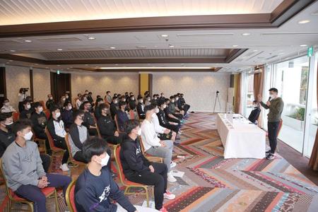 　キャンプ前のミーティングで、選手の前で話す矢野監督（右奥）＝球団提供