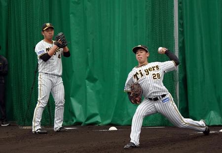 　ブルペンで投球練習する桐敷（左）と鈴木（撮影・山口登）