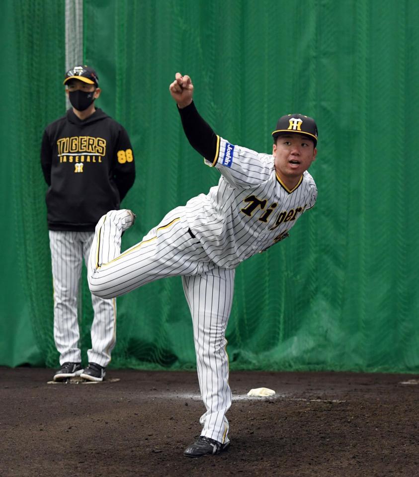 ブルペンで投球練習する村上（左は矢野監督）＝撮影・山口登