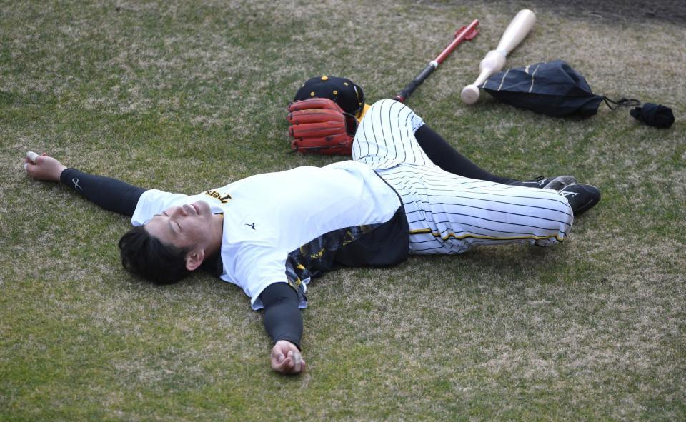 　屋外での練習を終え、球場に寝そべる原口（撮影・石井剣太郎）