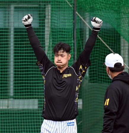 　阪神・佐藤輝はロングティーで納得する打球を放ち、ほっぺたを膨らませ両手でガッツポーズする（撮影・山口登）