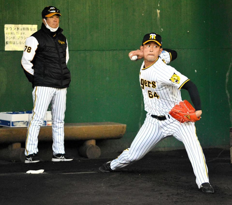 　平田２軍監督（左）が見守る中、投球する岡留（撮影・間宮涼）