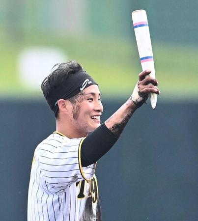 　井上コーチの折れたノックバットを掲げる木浪（撮影・田中太一）