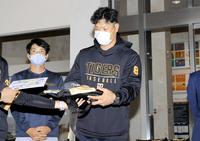 　こども医療センターに訪問し、タイガースグッズを病院の関係者に渡す佐藤輝（右）。左は高寺（代表撮影）