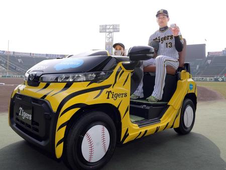 　新しいリリーフカーに乗ってポーズを決める岩崎