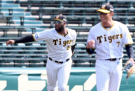 　シートノックで本塁へ送球するロハス。手前右は糸井（撮影・田中太一）