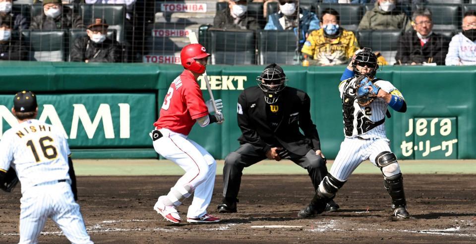 　３回、素早いスローイングで三塁走者の大盛を刺す梅野（右、打者・西川）＝撮影・飯室逸平