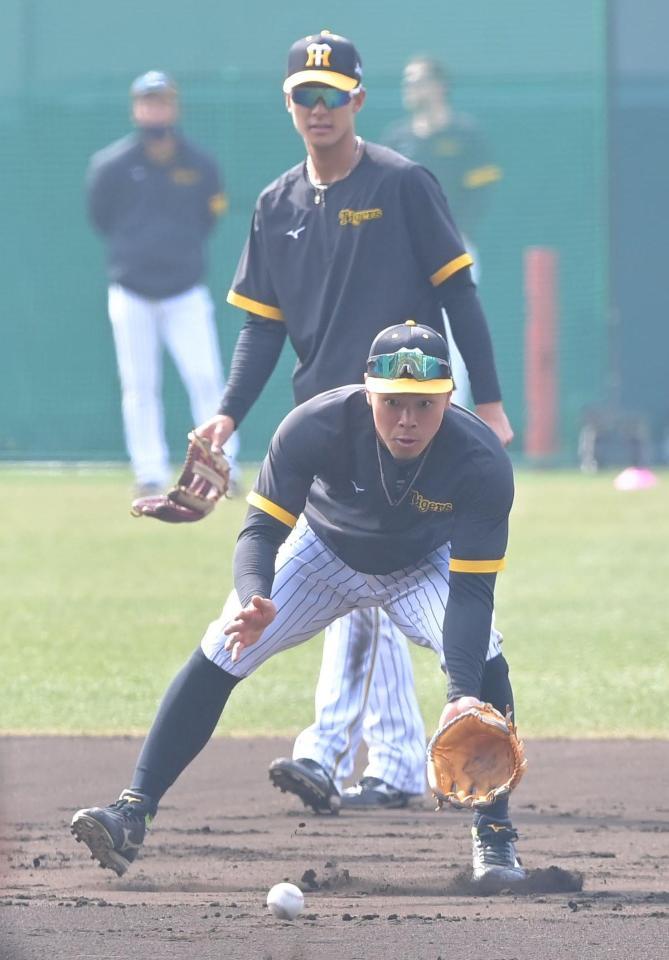 　試合前、小幡（奥）と共にセカンドの位置でノックを受ける佐藤輝（撮影・高部洋祐）