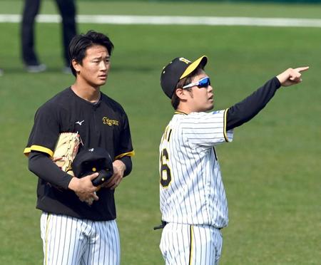 　初めての甲子園練習で西勇（右）からアドバイスを受ける森木（撮影・山口登）