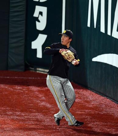 　試合前練習でフェンス際のボールを処理する前川（撮影・山口登）