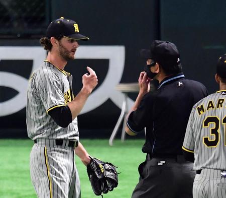 　６回、ケラー（左）は梅木塁審から注意を受ける（撮影・山口登）