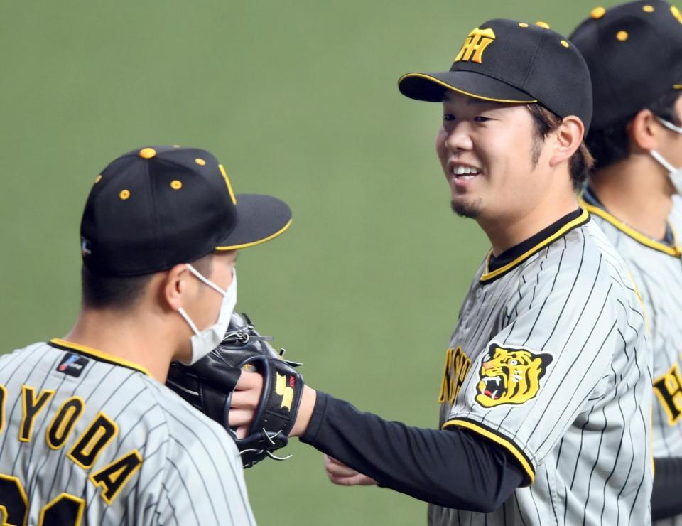 　１回を無失点に抑えナインとタッチを交わす西勇（撮影・田中太一）