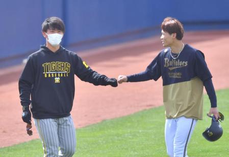 　試合前、オリックス・中川（右）とタッチを交わす阪神・伊藤将（撮影・吉澤敬太）