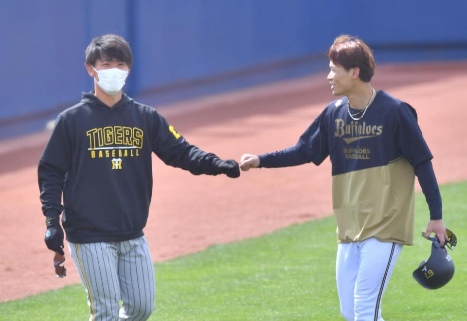 　試合前、オリックス・中川（右）とタッチを交わす阪神・伊藤将（撮影・吉澤敬太）