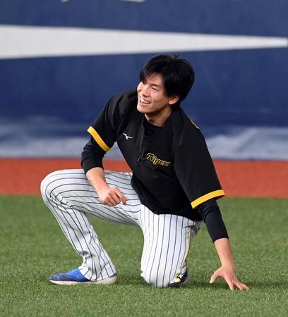 練習中、笑顔を見せる阪神・湯浅京己＝京セラドーム大阪（撮影・山口登）