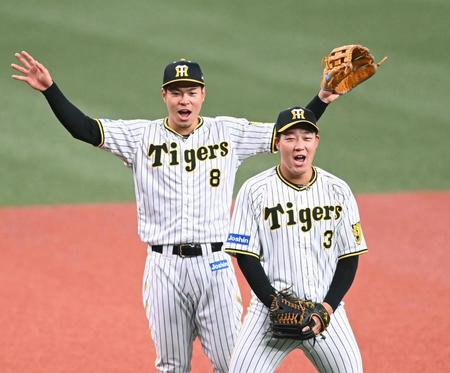 　三塁でノックを受ける佐藤輝（左）と大山