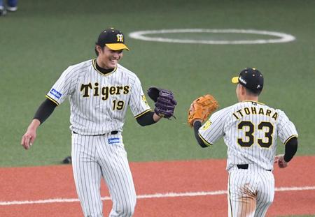 　４回、藤浪は古賀を併殺に打ち取り笑顔で糸原とグラブタッチする（撮影・山口登）