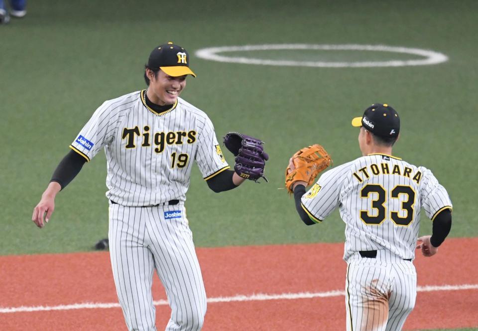 　４回、藤浪は古賀を併殺に打ち取り笑顔で糸原とグラブタッチする（撮影・山口登）