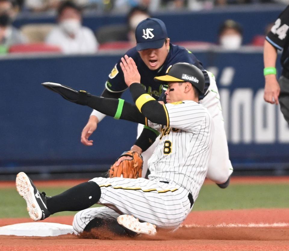 　滑り込む佐藤輝は村上の捕球ミスを誘う（撮影・田中太一）