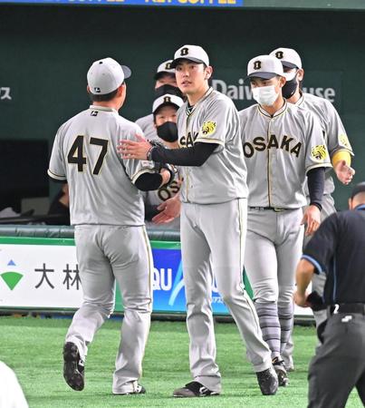 　５回、好リリーフを見せる桐敷（左）を迎える小川（撮影・堀内翔）