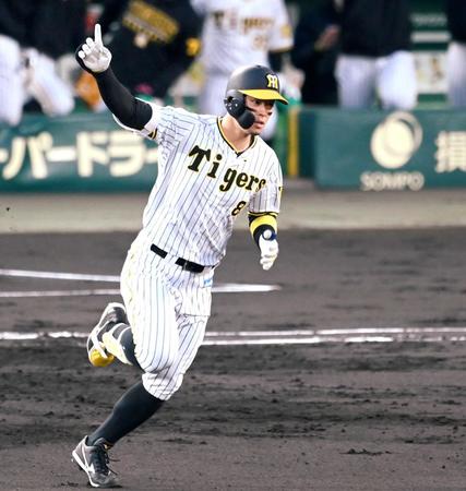 　１回、１号２ランを放ち、手を上げてダイヤモンドを回る佐藤輝（撮影・飯室逸平）