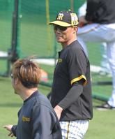 　試合前、甲子園球場のゲスト用パスを帽子に貼って、西勇（手前）と談笑する糸井