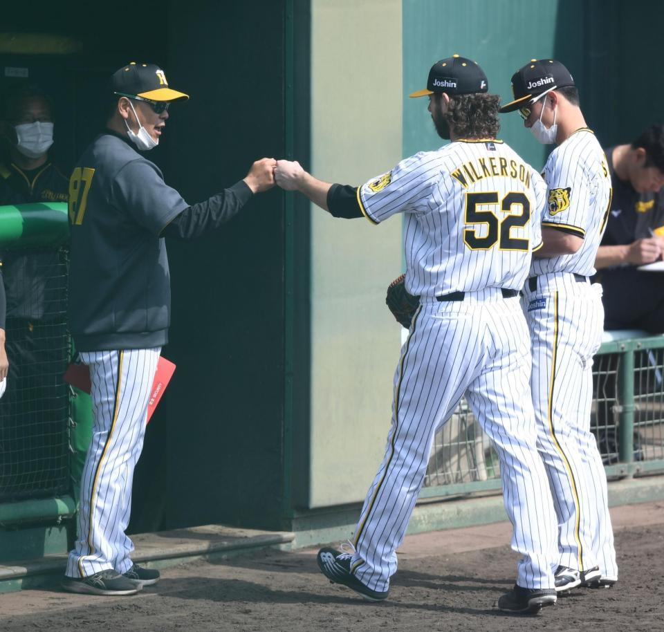 　６回、得点を許さず投げ終え、コーチらとタッチをかわすウィルカーソン（５２）＝撮影・石井剣太郎