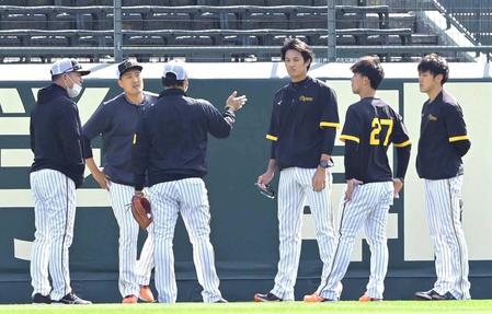 　コーチの話を聞く秋山（左）、藤浪（右から３人目）ら投手陣