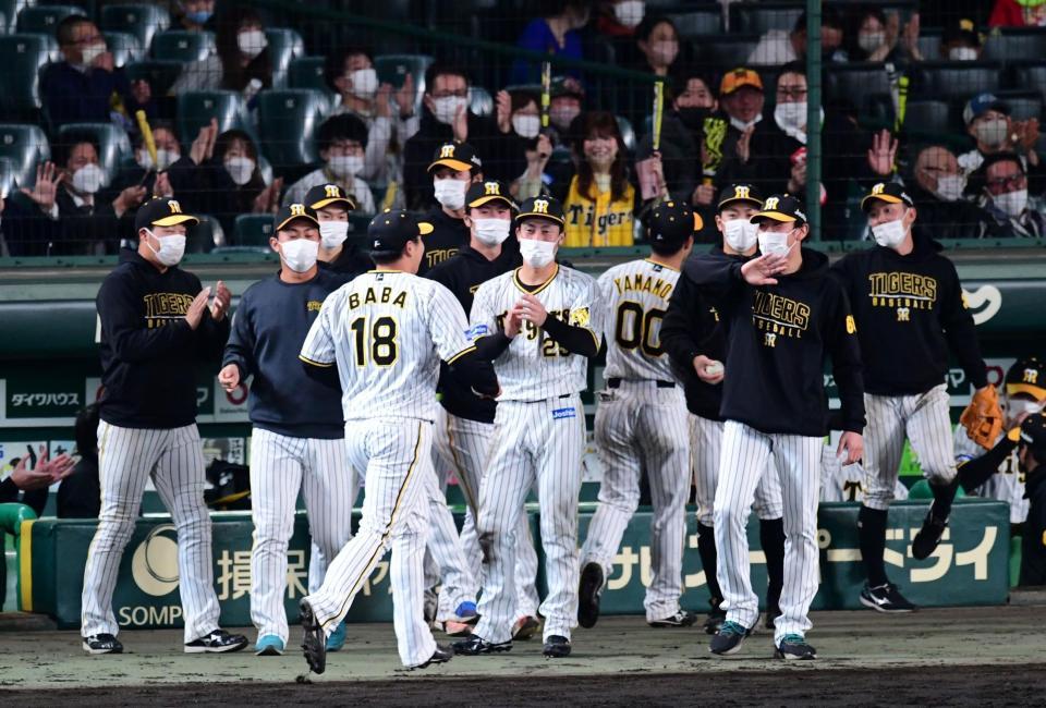 　延長１２回、好投した阪神・馬場を迎えるナイン（撮影・山口登）