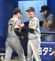 　５回、好リリーフを見せた岩貞（１７）を笑顔で迎える小川（撮影・飯室逸平）